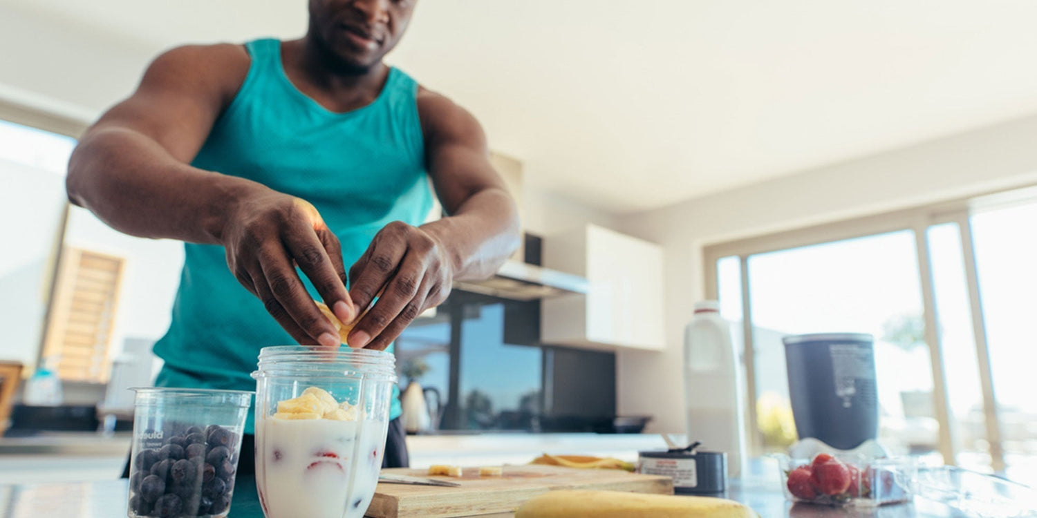 Man making protein shake in kitchen